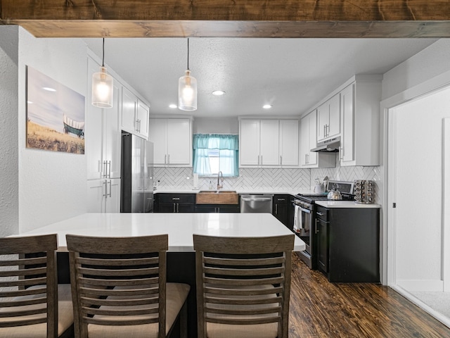 kitchen featuring sink, appliances with stainless steel finishes, white cabinetry, hanging light fixtures, and backsplash