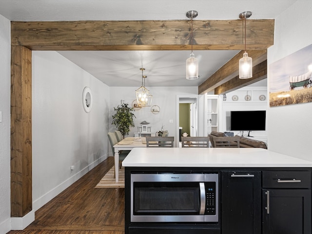 kitchen with pendant lighting, dark wood-type flooring, and beamed ceiling