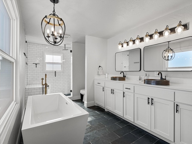 bathroom featuring vanity, independent shower and bath, a textured ceiling, and a wealth of natural light