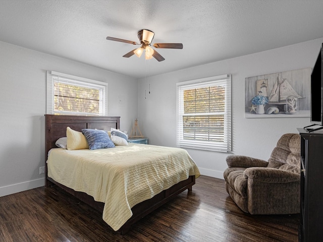 bedroom featuring multiple windows, dark wood-type flooring, and a textured ceiling