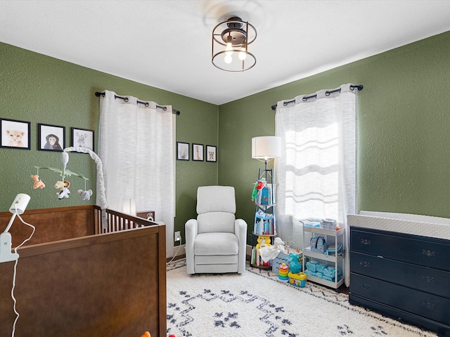 carpeted bedroom with a nursery area