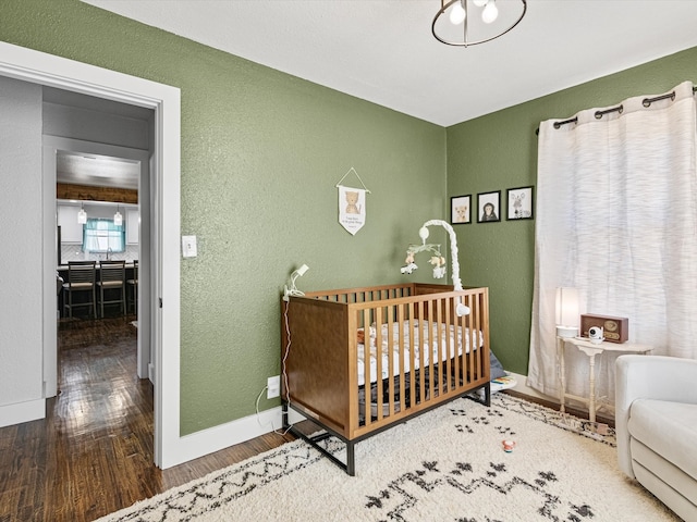 bedroom featuring hardwood / wood-style flooring and a nursery area