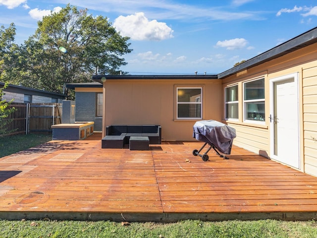 wooden terrace featuring an outdoor living space and area for grilling