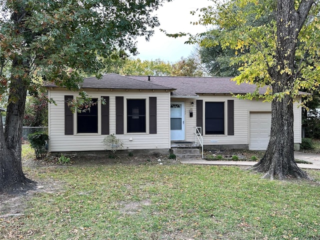 ranch-style home featuring a garage and a front lawn