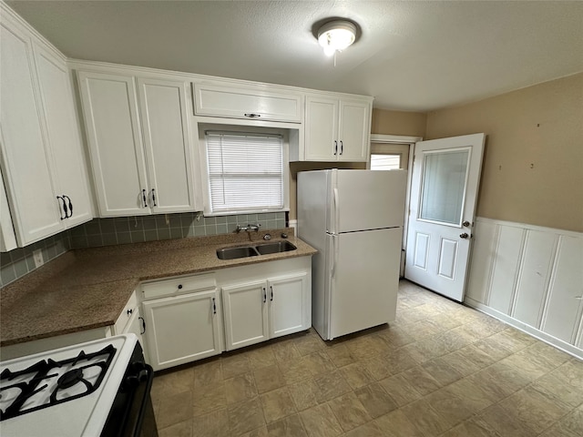 kitchen with white cabinets, white appliances, backsplash, and sink