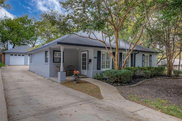 single story home with an outbuilding, brick siding, roof with shingles, concrete driveway, and a garage