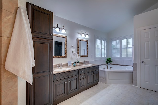 bathroom featuring a tub, vanity, and vaulted ceiling