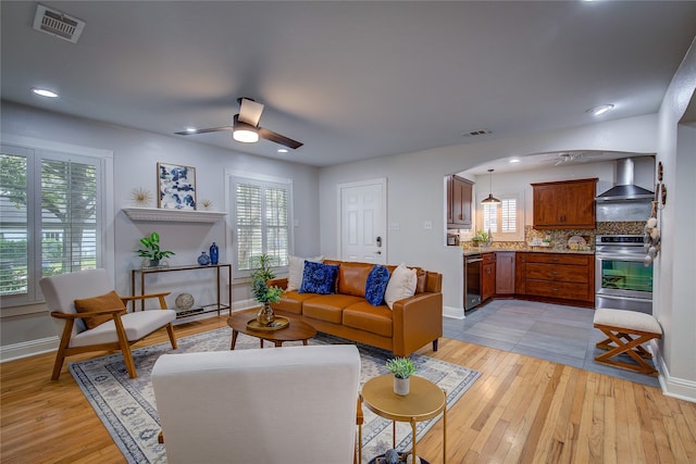 living room featuring light hardwood / wood-style floors and ceiling fan