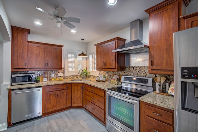 kitchen with decorative backsplash, stainless steel appliances, sink, wall chimney range hood, and pendant lighting