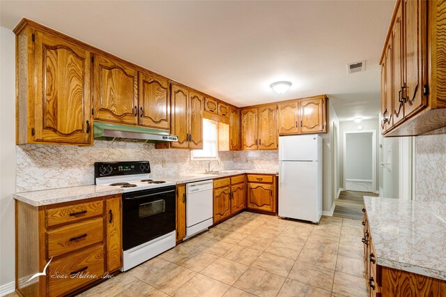 kitchen featuring decorative backsplash, white appliances, and sink