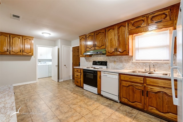 kitchen featuring decorative backsplash, white appliances, sink, and separate washer and dryer