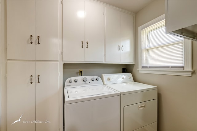 clothes washing area with cabinets and washer and dryer