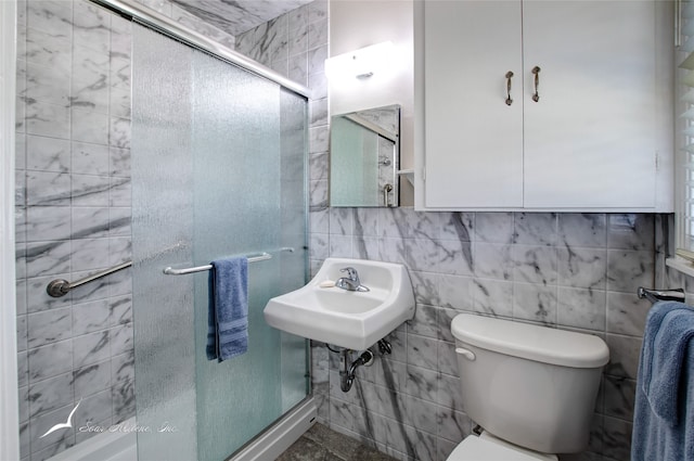 bathroom with walk in shower, sink, tile walls, and toilet