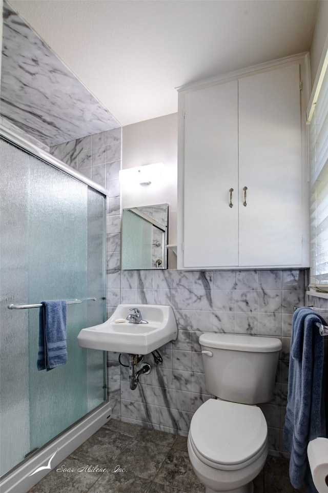 bathroom featuring toilet, sink, tile walls, and walk in shower