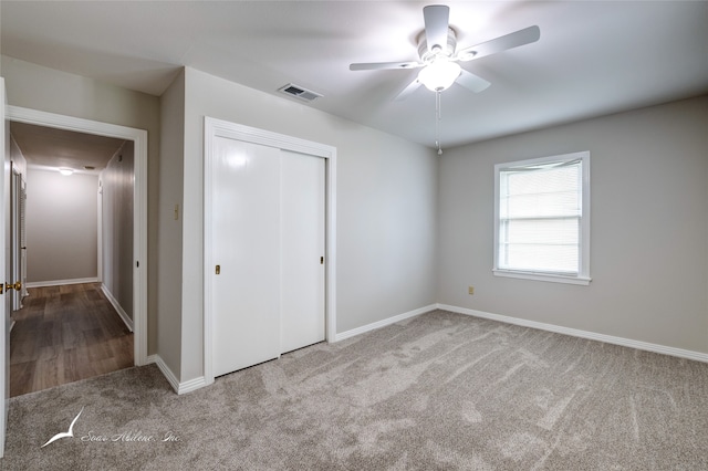 unfurnished bedroom with ceiling fan, a closet, and light colored carpet