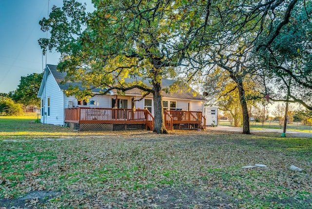 view of front facade with a deck and a front lawn