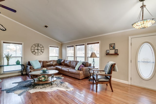 living room with light wood-type flooring, a wealth of natural light, and crown molding