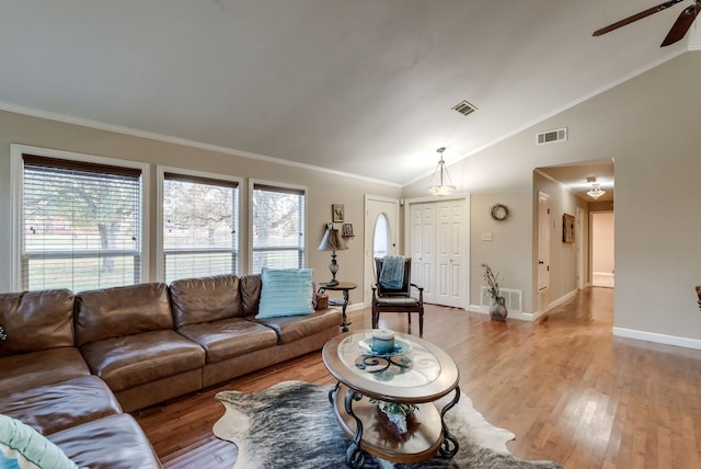 living room with lofted ceiling, crown molding, light hardwood / wood-style floors, and ceiling fan