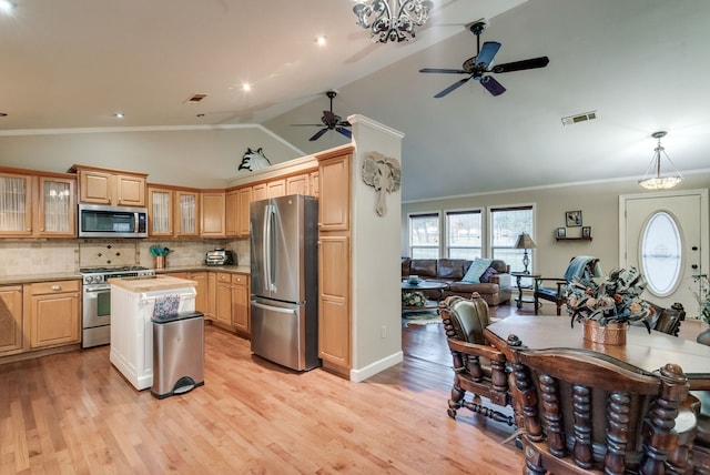 kitchen featuring crown molding, stainless steel appliances, decorative backsplash, and light wood-type flooring