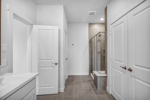 bathroom featuring tile patterned flooring, vanity, and a shower with door