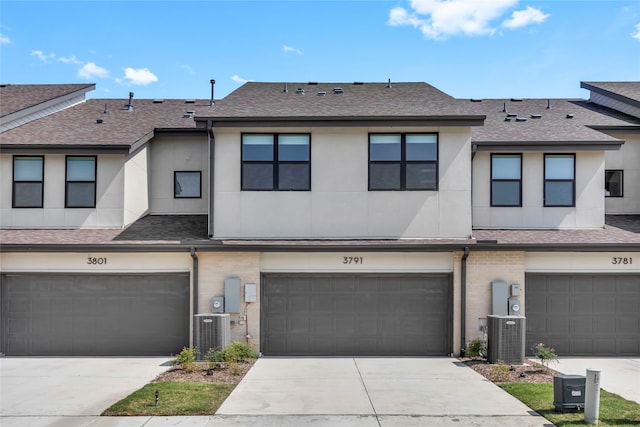 townhome / multi-family property featuring a garage and cooling unit