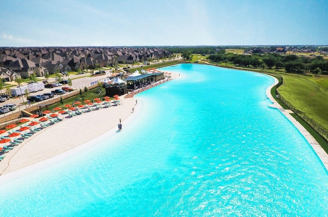 view of pool with a water view and a beach view