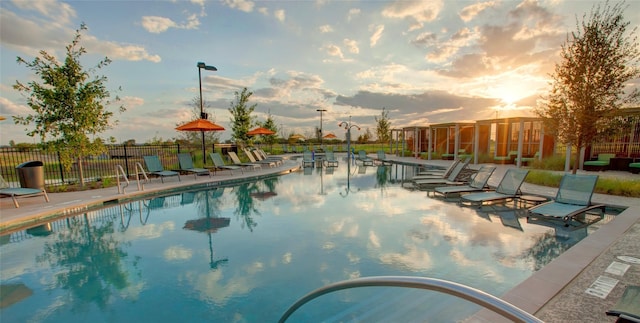 pool at dusk featuring a patio area