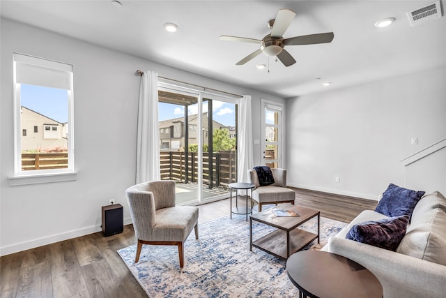 living room featuring ceiling fan and dark hardwood / wood-style flooring