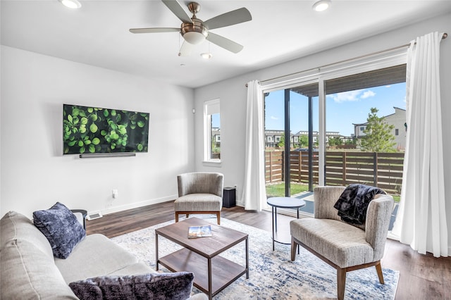 living room with ceiling fan and dark wood-type flooring