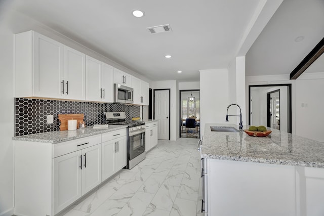 kitchen featuring white cabinets, light stone counters, sink, and stainless steel appliances