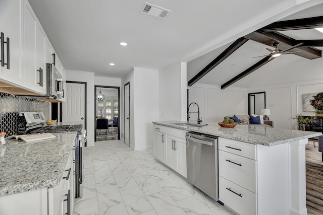 kitchen featuring appliances with stainless steel finishes, light stone counters, sink, beamed ceiling, and white cabinetry