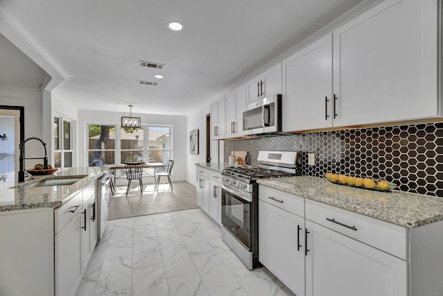 kitchen featuring decorative light fixtures, sink, appliances with stainless steel finishes, and tasteful backsplash