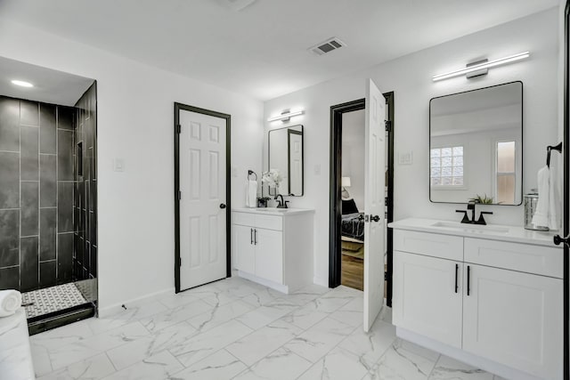 bathroom with tiled shower and vanity