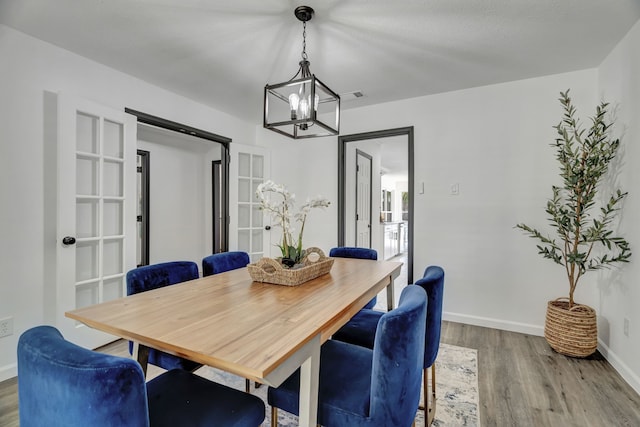 dining area with hardwood / wood-style floors and a chandelier