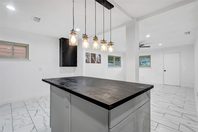 kitchen with hanging light fixtures, a kitchen island, and ceiling fan