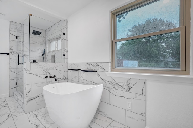 bathroom featuring a healthy amount of sunlight, tile walls, and shower with separate bathtub