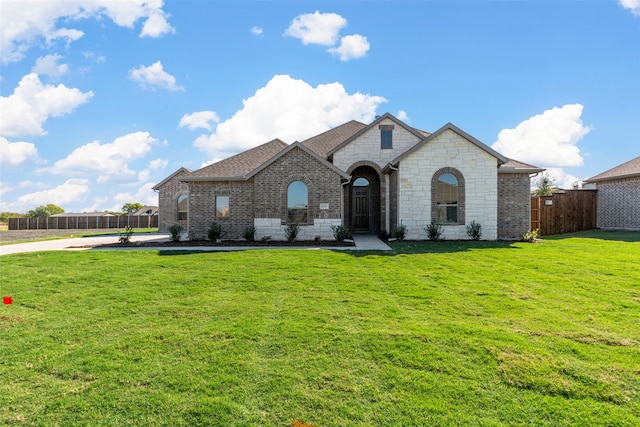 french country inspired facade with a front lawn