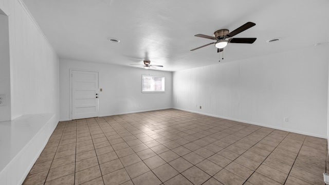 tiled spare room with ceiling fan