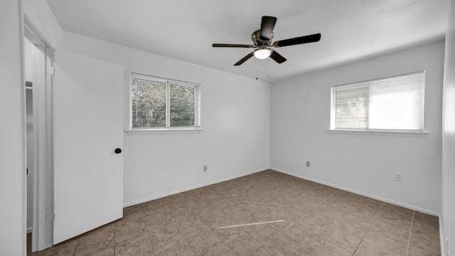 spare room featuring ceiling fan and a wealth of natural light