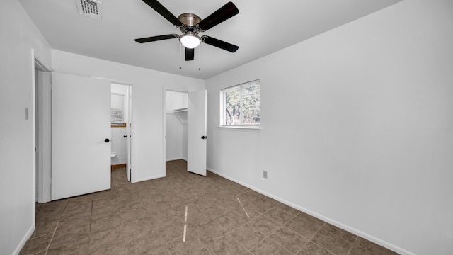 unfurnished bedroom featuring ceiling fan, a walk in closet, and a closet