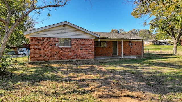 rear view of property featuring a yard and a patio