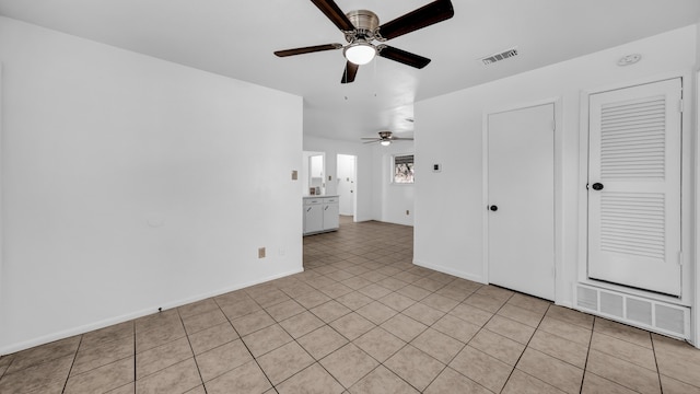 tiled spare room featuring ceiling fan