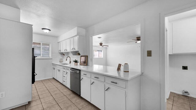 kitchen with stainless steel dishwasher, sink, white refrigerator, white cabinetry, and light tile patterned flooring