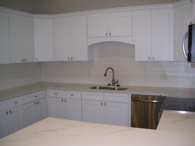 kitchen featuring tasteful backsplash, appliances with stainless steel finishes, sink, and white cabinets