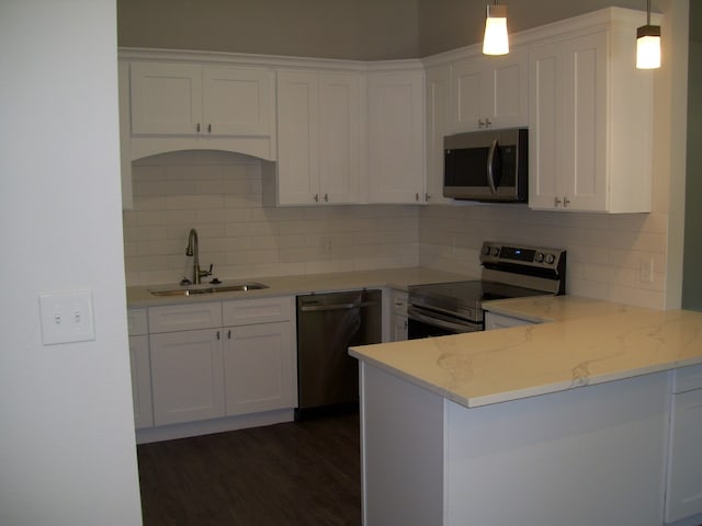 kitchen with sink, white cabinets, pendant lighting, and appliances with stainless steel finishes