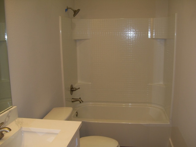 full bathroom featuring vanity, tiled shower / bath combo, and toilet