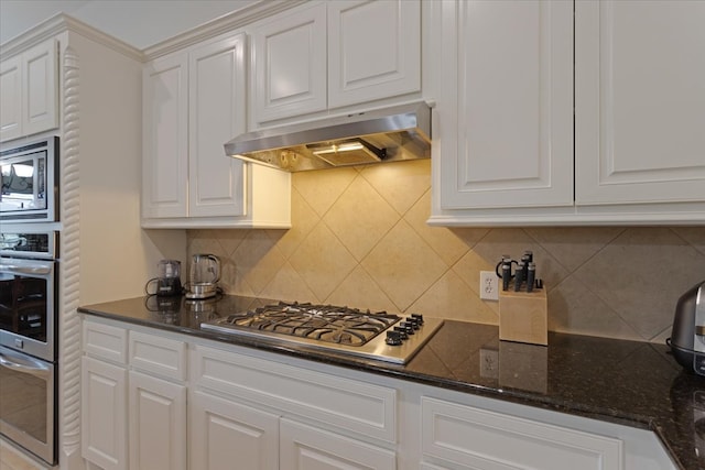 kitchen featuring white cabinets, appliances with stainless steel finishes, decorative backsplash, and range hood