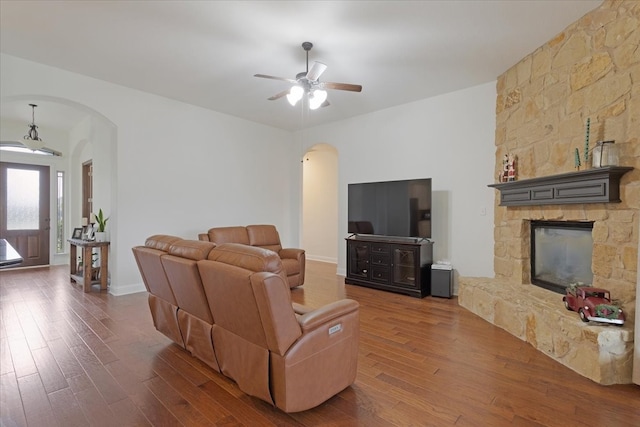 living room with a fireplace, dark hardwood / wood-style floors, and ceiling fan