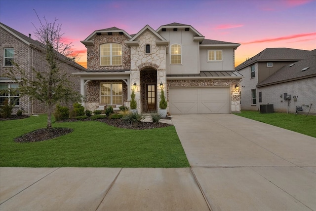 view of front of house featuring central AC unit, a garage, and a lawn