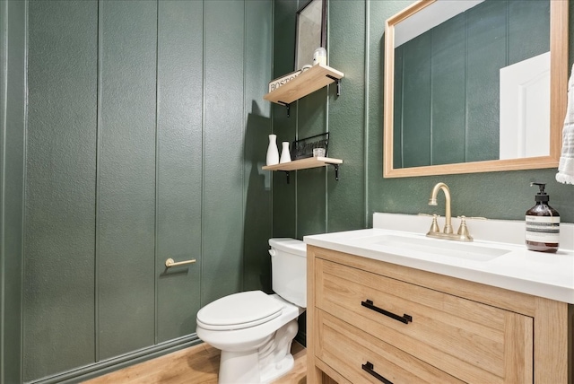 bathroom with vanity, toilet, and wood-type flooring